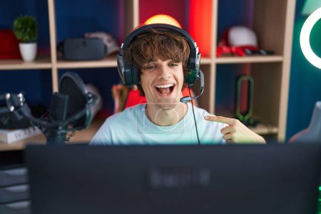 Photo for Hispanic young man playing video games smiling happy pointing with hand and finger - Royalty Free Image