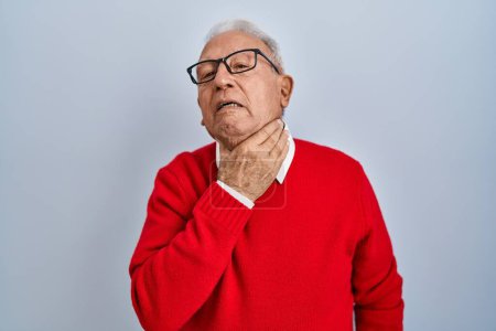 Foto de Hombre mayor con el pelo gris de pie sobre el fondo aislado tocando el cuello doloroso, dolor de garganta para la gripe, la clod y la infección - Imagen libre de derechos