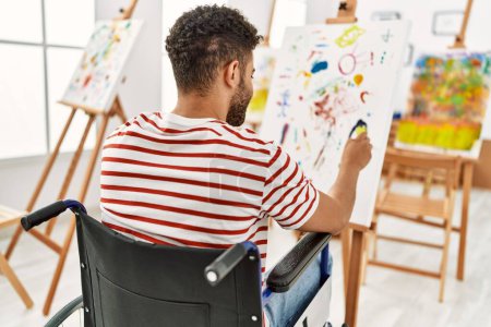 Photo for Young arab disabled artist man on back view drawing sitting on wheelchair at art studio. - Royalty Free Image