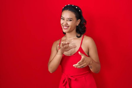 Téléchargez les photos : Young hispanic woman standing over red background disgusted expression, displeased and fearful doing disgust face because aversion reaction. with hands raised - en image libre de droit
