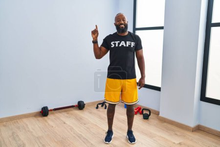 Photo for African american man working at fitness gym smiling with an idea or question pointing finger up with happy face, number one - Royalty Free Image