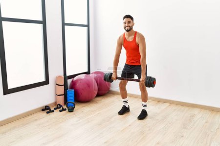 Photo for Young arab man smiling confident training with dumbbells at sport center - Royalty Free Image