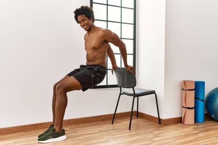 Foto de Joven afroamericano hombre entrenamiento flexiones en el gimnasio - Imagen libre de derechos