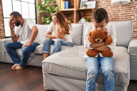 Familie sitzt auf Sofa und Kind traurig über Elternstreit zu Hause