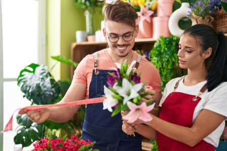 Téléchargez les photos : Fleuristes hommes et femmes tenant bouquet de fleurs et dentelle cadeau à la boutique de fleurs - en image libre de droit