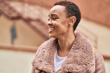 Foto de Mujer afroamericana sonriendo confiada mirando a un lado en la calle - Imagen libre de derechos