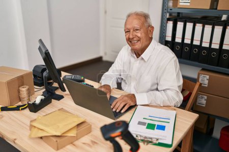 Téléchargez les photos : Senior homme ecommerce travailleur d'affaires en utilisant un ordinateur portable au bureau - en image libre de droit
