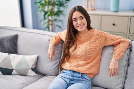 Photo for Young beautiful hispanic woman smiling confident sitting on sofa at home - Royalty Free Image