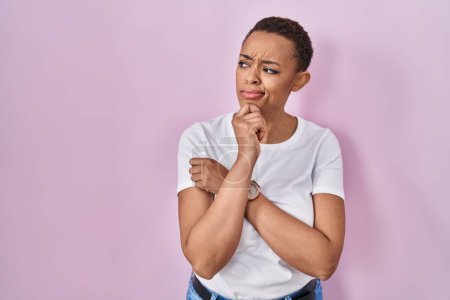Photo for Beautiful african american woman standing over pink background thinking worried about a question, concerned and nervous with hand on chin - Royalty Free Image