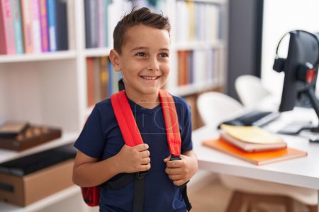 Téléchargez les photos : Adorable élève hispanique tout-petit souriant debout avec confiance à l'école de bibliothèque - en image libre de droit