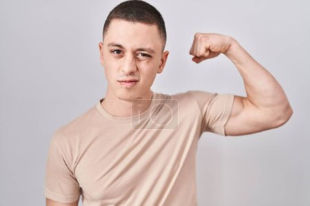 Photo for Young man standing over isolated background strong person showing arm muscle, confident and proud of power - Royalty Free Image