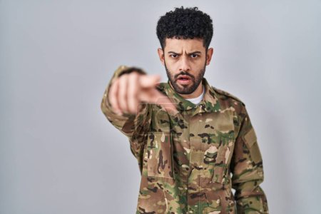 Foto de Hombre árabe vistiendo camuflaje uniforme del ejército señalando disgustado y frustrado a la cámara, enojado y furioso contigo - Imagen libre de derechos