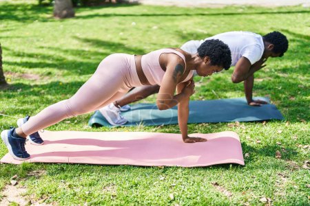 Photo for African american man and woman couple training push up at park - Royalty Free Image