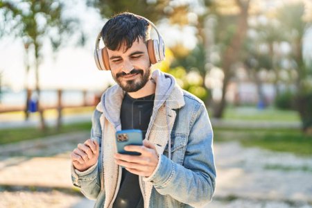 Téléchargez les photos : Young hispanic man smiling confident listening to music at park - en image libre de droit