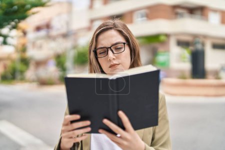 Téléchargez les photos : Young woman business worker reading book at street - en image libre de droit