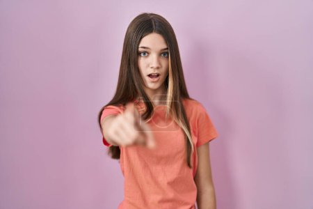 Foto de Teenager girl standing over pink background pointing displeased and frustrated to the camera, angry and furious with you - Imagen libre de derechos