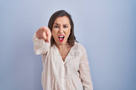 Photo for Middle age hispanic woman standing over blue background pointing displeased and frustrated to the camera, angry and furious with you - Royalty Free Image