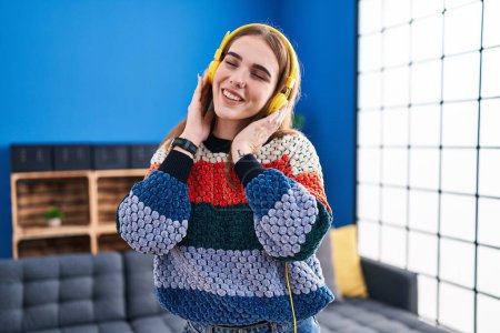 Téléchargez les photos : Young woman smiling confident listening to music at home - en image libre de droit