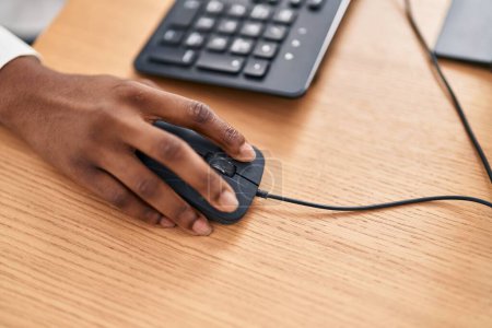 Téléchargez les photos : Femme afro-américaine en utilisant une souris d'ordinateur au bureau - en image libre de droit