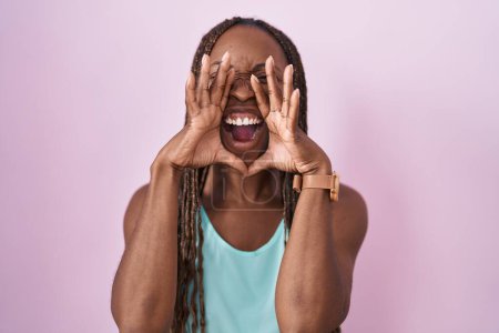 Photo for African american woman standing over pink background shouting angry out loud with hands over mouth - Royalty Free Image