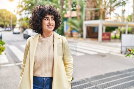 Téléchargez les photos : Jeune femme du Moyen-Orient excutive souriant confiant regardant vers le côté à la rue - en image libre de droit