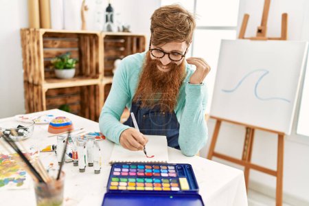 Photo for Young redhead man smiling confident drawing on notebook at art studio - Royalty Free Image