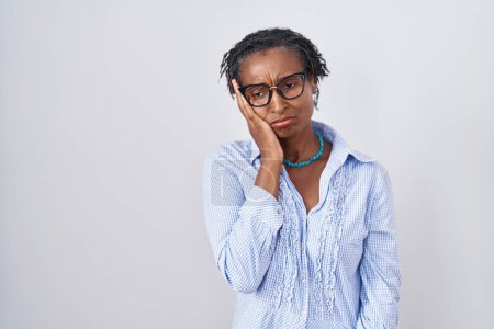 Foto de African woman with dreadlocks standing over white background wearing glasses thinking looking tired and bored with depression problems with crossed arms. - Imagen libre de derechos