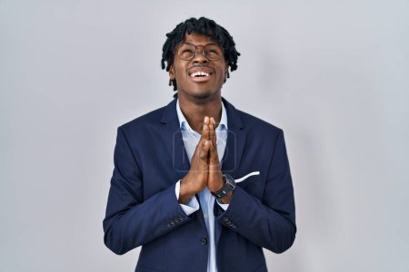Photo for Young african man with dreadlocks wearing business jacket over white background begging and praying with hands together with hope expression on face very emotional and worried. begging. - Royalty Free Image