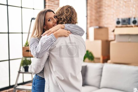 Photo for Man and woman couple hugging each other standing at new home - Royalty Free Image