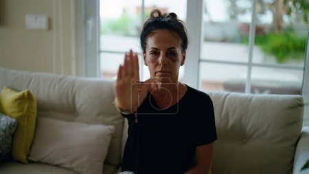 Téléchargez les photos : Femme hispanique du Moyen Âge faisant un geste d'arrêt pour violence domestique à la maison - en image libre de droit
