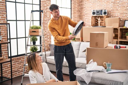 Photo for Young man and woman couple smiling confident unpacking cardboard box at new home - Royalty Free Image