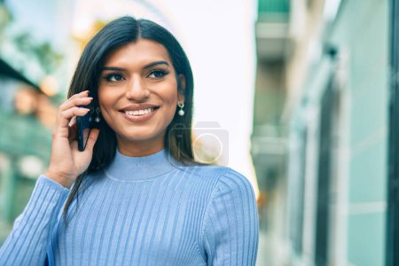Téléchargez les photos : Jeune femme hispanique parlant au téléphone à la ville - en image libre de droit