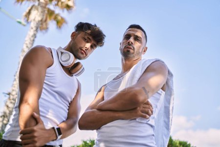 Téléchargez les photos : Two hispanic men sporty couple standing with arms crossed gesture at street - en image libre de droit