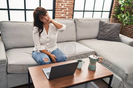 Photo for Young beautiful hispanic woman using laptop stressed at home - Royalty Free Image