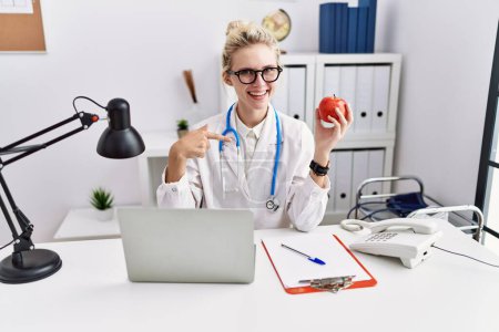 Photo for Young doctor woman working at dietitian clinic pointing finger to one self smiling happy and proud - Royalty Free Image