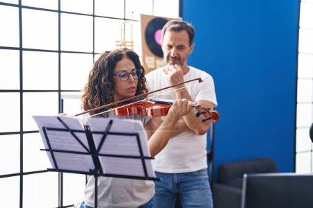 Photo for Man and woman violinist having violin lesson at music studio - Royalty Free Image