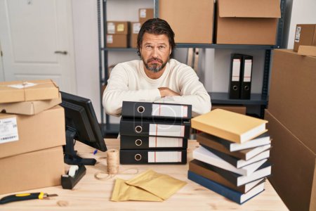 Foto de Handsome middle age man working at small business ecommerce depressed and worry for distress, crying angry and afraid. sad expression. - Imagen libre de derechos