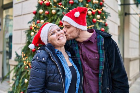 Photo for Mother and son smiling confident standing by christmas tree at street - Royalty Free Image