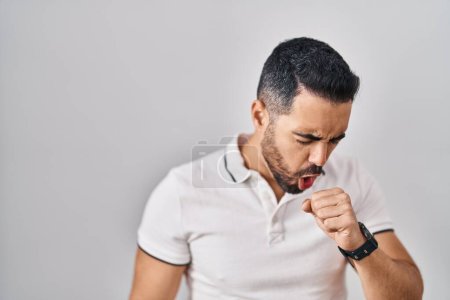 Photo for Young hispanic man with beard wearing casual clothes over white background feeling unwell and coughing as symptom for cold or bronchitis. health care concept. - Royalty Free Image