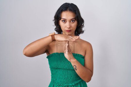 Téléchargez les photos : Young hispanic woman standing over isolated background doing time out gesture with hands, frustrated and serious face - en image libre de droit