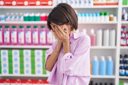 Téléchargez les photos : Jeune fille à la pharmacie pharmacie avec expression triste couvrant le visage avec les mains tout en pleurant. concept de dépression. - en image libre de droit