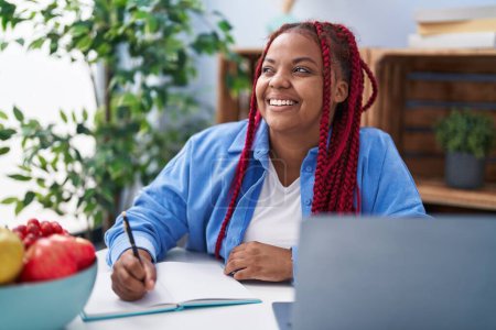 Téléchargez les photos : African american woman smiling confident studying at home - en image libre de droit