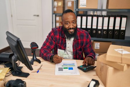Téléchargez les photos : Jeune homme afro-américain commerce électronique travailleur d'affaires comptant des dollars au bureau - en image libre de droit