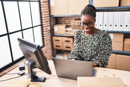 Téléchargez les photos : Africaine américaine femme commerce électronique travailleur d'affaires en utilisant un ordinateur portable travaillant au bureau - en image libre de droit