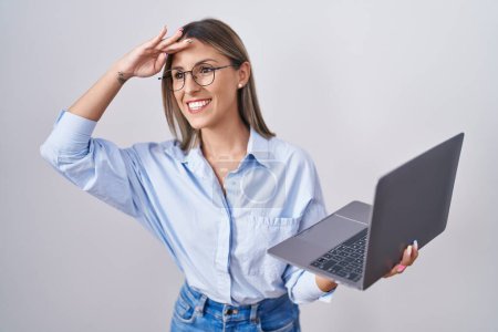 Photo for Young woman working using computer laptop very happy and smiling looking far away with hand over head. searching concept. - Royalty Free Image