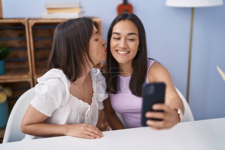 Foto de Two women mother and daughter make selfie by smartphone at home - Imagen libre de derechos