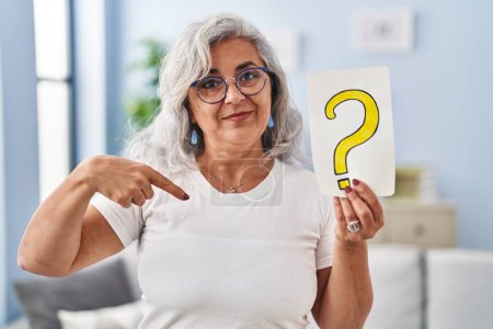 Photo for Middle age woman with grey hair holding question mark pointing finger to one self smiling happy and proud - Royalty Free Image