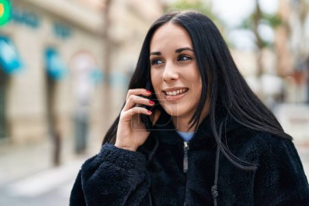 Foto de Young caucasian woman smiling confident talking on smartphone at street - Imagen libre de derechos