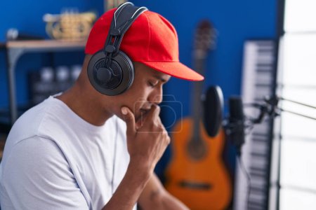 Foto de Joven músico latino escuchando música en el estudio de música - Imagen libre de derechos