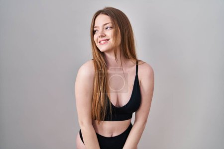 Foto de Young caucasian woman wearing lingerie looking away to side with smile on face, natural expression. laughing confident. - Imagen libre de derechos
